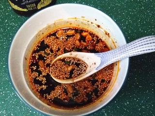 7、口水鸡,此时来调浇汁：碗中放入食盐、白糖、香醋、蒜泥、芝麻，花生米、鲜酱油和香辣豆豉酱，再加少许鸡汤搅拌均匀