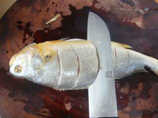 2、清蒸黄鱼,把鱼去内脏和腹部内的黑膜，去鳞去鱼鳃两面都切花刀