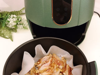 12、蒜香鸡翅,放入空气炸锅中，选择【鸡翅】键，默认185度20分钟。