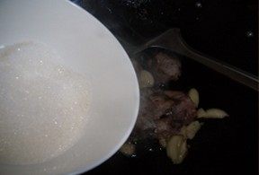 3、干炒橙香排骨,倒入一大把的白糖继续煸炒至排骨变成紫红色