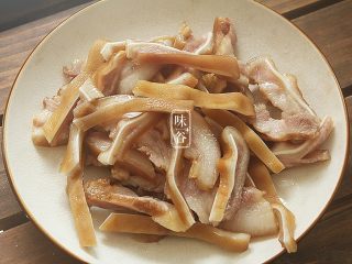 7、下酒小菜~凉拌猪耳,大火煮开后中小火煮30分钟后捞起晾凉,切成细条;