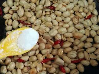 8、酒鬼花生,炒出麻香味时，倒入花生米，加入适量盐，白糖翻炒均匀。