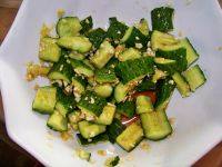 6、刀拍黄瓜,将糖、陈醋、蒸鱼豉油、纯黑芝麻油、姜蒜加入黄瓜段中，混合均匀