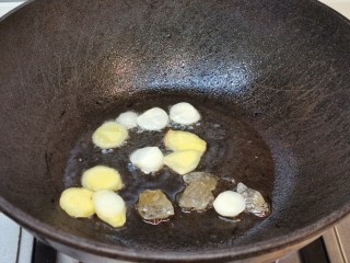 4、秋葵红烧排骨【简单入味】,锅烧热下油，爆香姜蒜，放入冰糖。