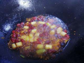 5、水煮牛肉,锅里加入平时炒菜多两倍的油,烧热后加入姜蒜(留一部分蒜末起来)和大葱白炒香,放入豆瓣酱炒出红油,最后放入干辣椒和花椒炒香。