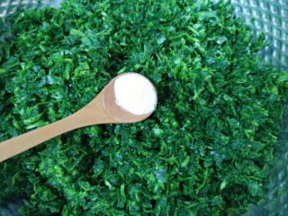 4、蒸苜蓿菜饼,放入盆里，加入食用碱抓匀。