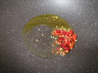 12、蒸苜蓿菜饼,炒锅内倒适量的食用油烧热，下入干红辣椒和花椒爆香。