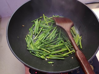 5、清炒韭菜花,下韭菜花轻炒。