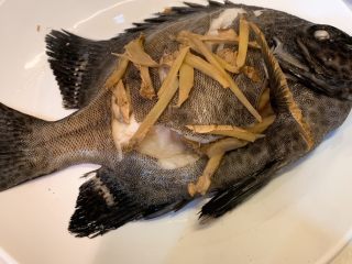 4、清蒸斑石鲷,蒸锅中取出鱼盘，把蒸汁倒掉