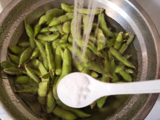 2、香辣毛豆,把毛豆放进盐水里面搓洗,这样比较容易洗净毛豆壳上的绒毛,然后用清水冲洗几次,洗好后控干水分。