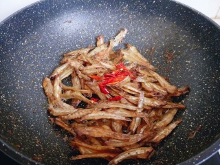8、#看球必备的零食&香辣小公鱼干,炒至变色后，加入切好的红辣椒。