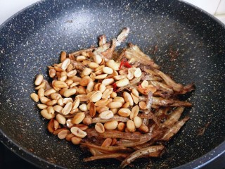 9、#看球必备的零食&香辣小公鱼干,最后加入烤好的花生米迅速翻炒，均匀即可关火出锅。