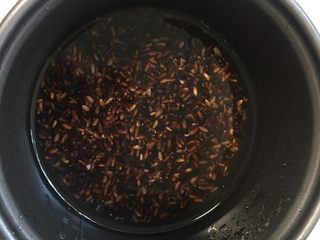 7、芒果黑米椰奶西米露,黑糯米加入白糖电饭锅里煮熟。