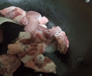 3、栗子红烧猪尾,加入猪尾不断翻炒，让猪尾上糖色