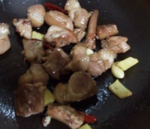 4、栗子红烧猪尾,加入姜片，蒜子和干辣椒，炒香