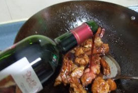 6、栗子红烧猪尾,加入白酒，翻炒一下，令猪尾巴吸收酒香