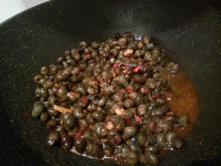 5、黑酱油#香辣螺蛳#,倒入螺蛳爆炒一分钟，