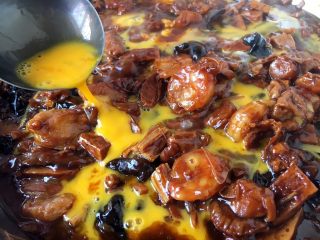 25、海鲜卤面,勾芡后改小火,淋入鸡蛋液。淋入蛋液时,先把鸡蛋打散,然后用筷子挡着往下流鸡蛋液的碗边,让鸡蛋液顺着筷子和碗边的空隙往下流,要转圈淋入鸡蛋液,让蛋液均匀分布在锅里,这时要有点小耐心等待蛋液定型哦。不过这步可以略去,您也可以把鸡蛋提前炒好,撒在盛在盆里的卤上。