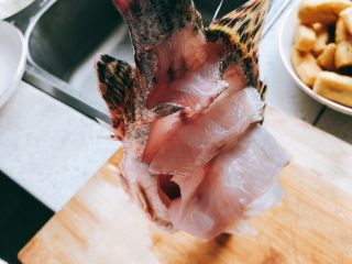 4、年年有余之糖醋鱼-年夜饭,切至拎起鱼尾,鱼肉自然下垂。