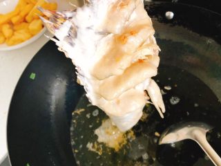 10、年年有余之糖醋鱼-年夜饭,锅里倒入食用油,烧至7层热时,手拎着鱼尾,将油从上到下浇到鱼身上,使刚才切的鱼片展开定型。