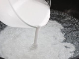 3、绿豆凉粉,将剩下的一千克清水倒入锅中,大火烧开。然后将稀释好的绿豆淀粉水缓缓倒入锅中,一边倒一边快速搅拌。