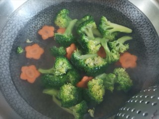 7、蒜蓉西兰花,水开下入西兰花和胡萝卜焯水一分钟，捞出控干水分