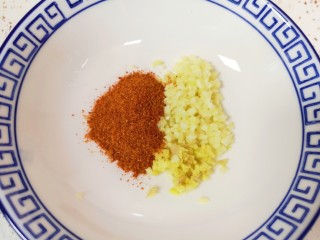 11、自制猪皮冻,蒜瓣和生姜剁成末，放入辣椒粉。 