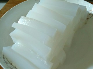2、酸辣凉粉,切成条，在盘子里摆好。