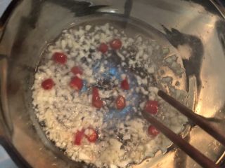 5、#爽口凉菜#凉拌黄花菜,倒入蒜末和辣椒粒炒香后关火备用