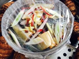 5、家常蒸咸鱼#有个故事#,锅中倒入适量的清水烧开后，把鱼打上保鲜膜放到蒸笼里