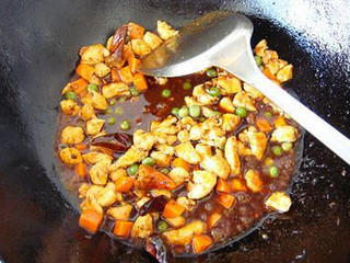 5、宫保鸡丁,倒入炒好的鸡丁和煮过的青豆和胡萝卜翻炒