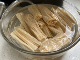 1、凉拌腐竹黄瓜,腐竹提前一晚用水浸泡，第二天早上腐竹变软捞出，再用开水烫一下杀菌，捞出来沥干水分备用。