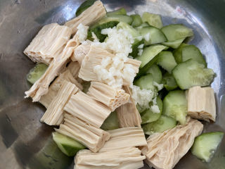 3、凉拌腐竹黄瓜,加入蒜末，拌均匀。