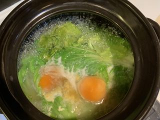 6、咸蛋芥菜汤,水再次煮开以后，就不要再盖锅盖了，磕下咸蛋，用筷子把咸蛋黄夹开会熟得更快点，用中大火煮15分钟
