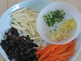 5、鱼香肉丝,冬笋切片后放进锅里用开水煮一下，捞起来切成丝，胡萝卜去皮切成丝，泡发的木耳切丝，姜蒜拍碎切末，葱切花。