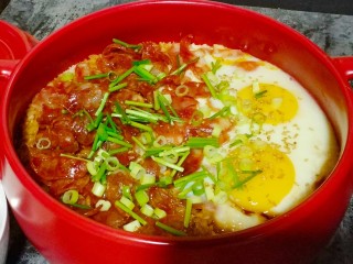 8、广式腊肠煲仔饭,淋上酱汁，撒上葱花和香菜段，端着灶台再焖两分钟就可以吃了。