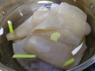 9、自制猪皮冻,猪皮再次冷水下锅，放葱段和姜片，料酒。