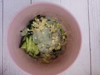 6、拉皮凉菜,然后把黄瓜拉皮还有蒜末放一个碗里