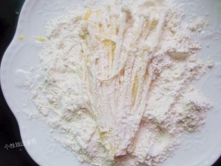 8、孜然黄金金针菇,带上一次性手套把金针菇从面里拿出来 用手从根部往下捋掉多余的面 不要让金针菇上挂太多的面 放进盘子里待炸就可以了