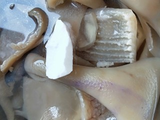 4、水晶五香猪皮冻,在放入盆中，加入一大块食用碱泡开，一小时后反复搓洗干净。