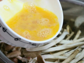 3、干煸茶树菇,将茶树菇清洗干净后，装入盆中，倒入蛋液、盐、黑胡椒粉～