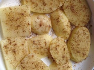 5、孜然烤土豆片,如图再撒上孜然粉铺匀，放置一边腌制一会儿