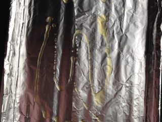 6、孜然烤土豆片,如图准备烤盘铺上锡纸，并在上面撒少许油，用勺子涂匀，以防土豆烤制时粘盘底