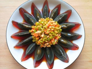 13、尖椒皮蛋,将调好的调料汁用勺子浇在皮蛋上面。