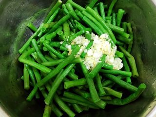 11、夏日清爽小凉菜——凉拌豆角,豆角沥干水倒入盆里，放入姜蒜水