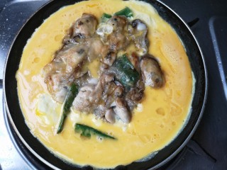 8、牡蛎炒蛋,翻一下煎另一面,在海蛎周围倒入蛋液。