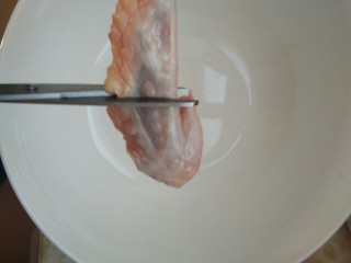 2、爽口鸡翅尖，年夜饭下酒菜,用剪刀在鸡翅尖中间剪断，分成两半。