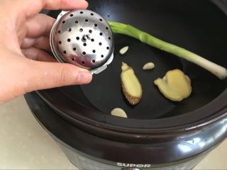 9、红油猪耳,将葱姜蒜放入锅底，大料花椒山楂干放入煮料盒，也放入锅内