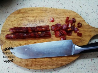 4、腊肠菜心粒,把腊肠冲洗干净，然后用刀切成小粒，不用腊肠可以用腊肉，火腿等。同时把蒜切成粒。