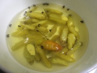 4、地方菜-泡椒花生米,准备好泡椒及泡椒水，放入姜片冰糖，花椒粒，也可以放一两个新鲜小米辣。